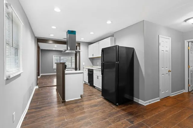 a view of a kitchen with refrigerator and wooden floor