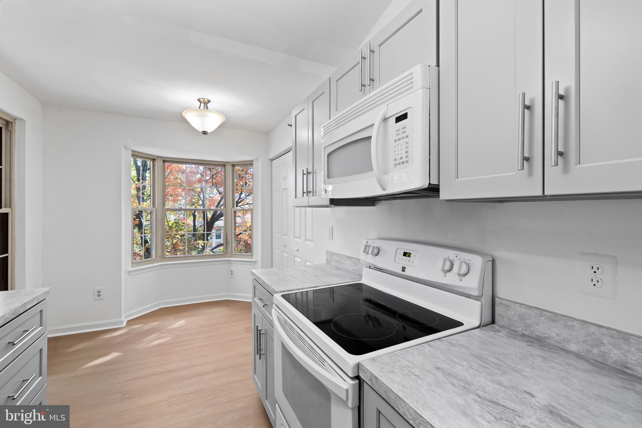 203 Star Pointe Court, Unit 3C Abingdon, MD 21009 - Photo 13 of 26 a kitchen with stainless steel appliances granite countertop a stove a microwave and a white cabinets