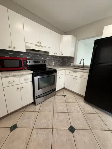 a kitchen with a stove a sink and a microwave