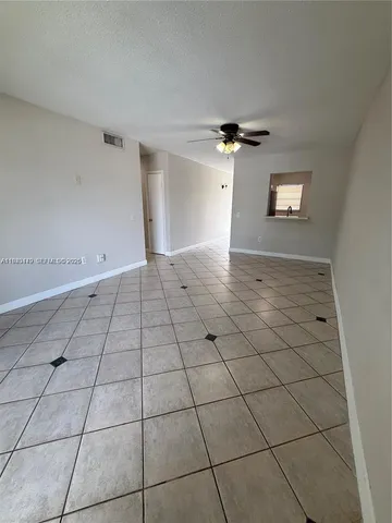 a view of a livingroom with a chandelier fan and windows