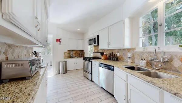 a kitchen with kitchen island a counter top space a sink and stainless steel appliances