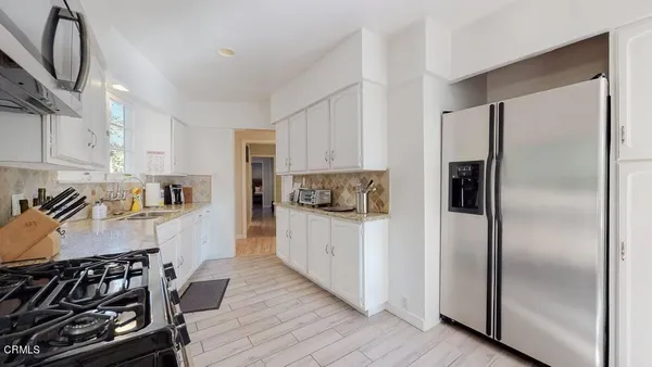 a kitchen with stainless steel appliances kitchen island granite countertop a stove a sink and a refrigerator