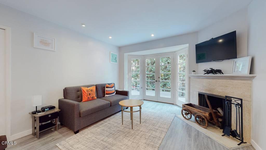 101 South Rockingham Avenue Los Angeles, CA 90049 - Photo 19 of 44 a living room with furniture a flat screen tv and a fireplace