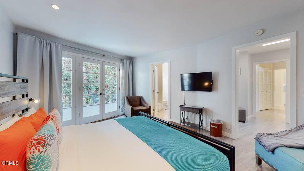 101 South Rockingham Avenue Los Angeles, CA 90049 - Photo 24 of 44 a bedroom with furniture and a flat screen tv