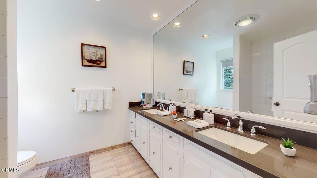 101 South Rockingham Avenue Los Angeles, CA 90049 - Photo 25 of 44 a large white room with a sink and mirror