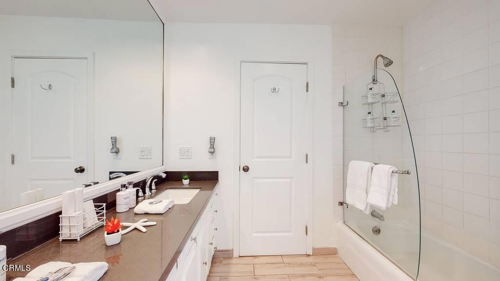 101 South Rockingham Avenue Los Angeles, CA 90049 - Photo 26 of 44 a bathroom with a tub sink and mirror