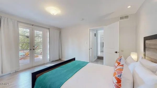 a bedroom with a bed and wooden floor