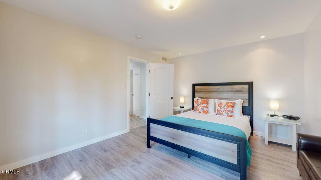 101 South Rockingham Avenue Los Angeles, CA 90049 - Photo 32 of 44 a bedroom with a bed and a wooden floor
