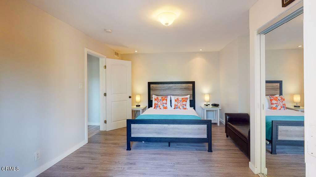 101 South Rockingham Avenue Los Angeles, CA 90049 - Photo 33 of 44 a bedroom with a bed and wooden floor