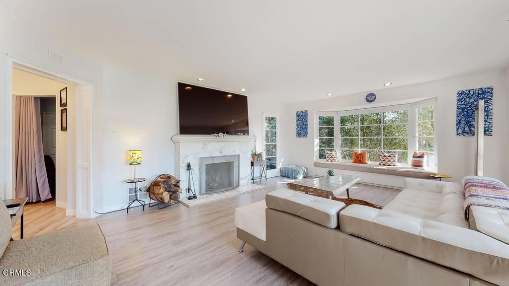 101 South Rockingham Avenue Los Angeles, CA 90049 - Photo 4 of 44 a living room with fireplace furniture and a flat screen tv