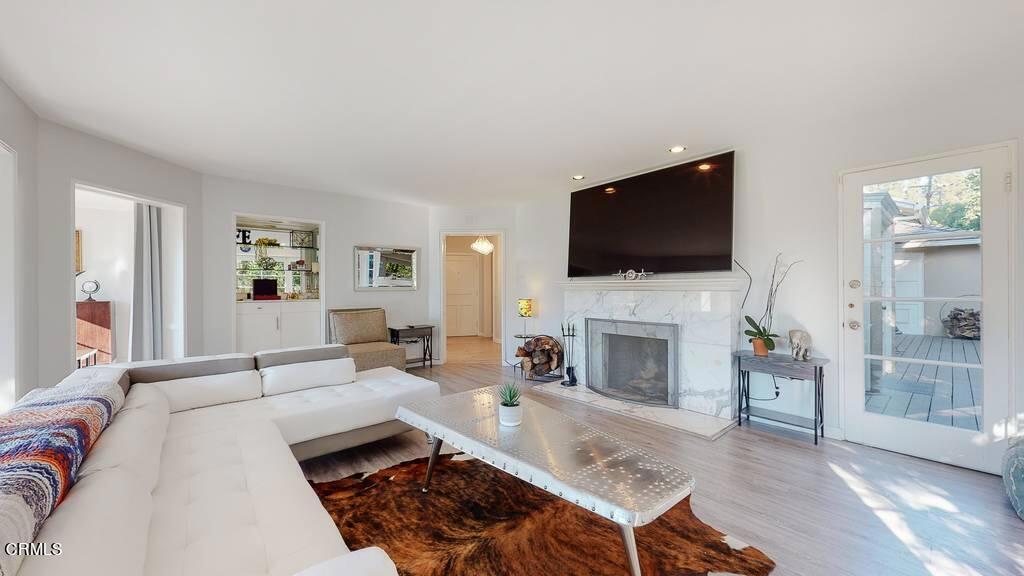 101 South Rockingham Avenue Los Angeles, CA 90049 - Photo 6 of 44 a living room with furniture a fireplace and a flat screen tv