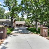 a front view of a house with a garden and tree