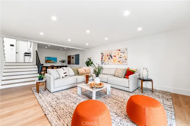 a living room with furniture kitchen view and a chandelier