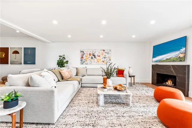 a living room with furniture a fireplace and a floor to ceiling window