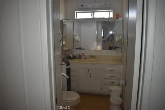 a bathroom with a granite countertop toilet sink and mirror