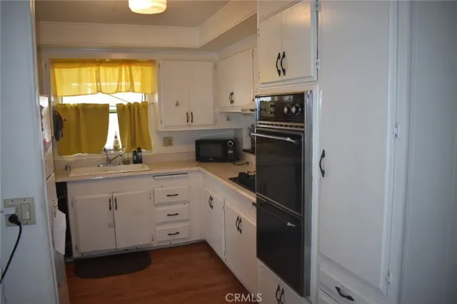 a kitchen with white cabinets and window