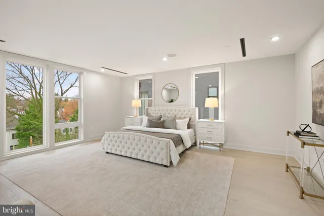 a spacious bedroom with a bed and glass walk in closet