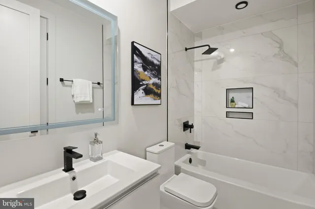 a kitchen with stainless steel appliances granite countertop a stove a refrigerator a sink a microwave oven with white cabinets and wooden floor