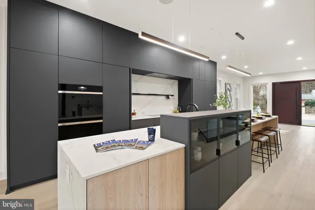 a large white kitchen with refrigerator stove dining table and chairs