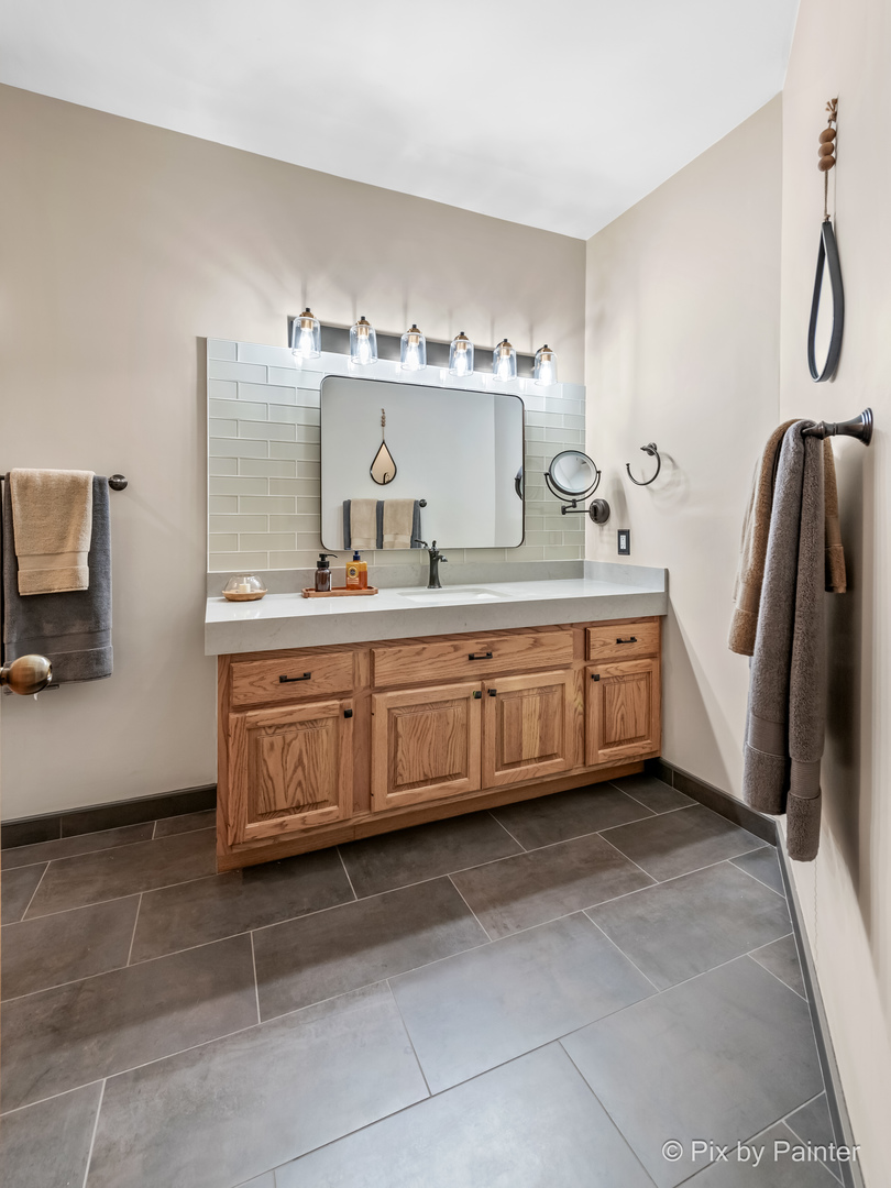 3804 Ridge Road Spring Grove, IL 60081 - Photo 35 of 55 a bathroom with a double vanity sink a mirror and bathtub