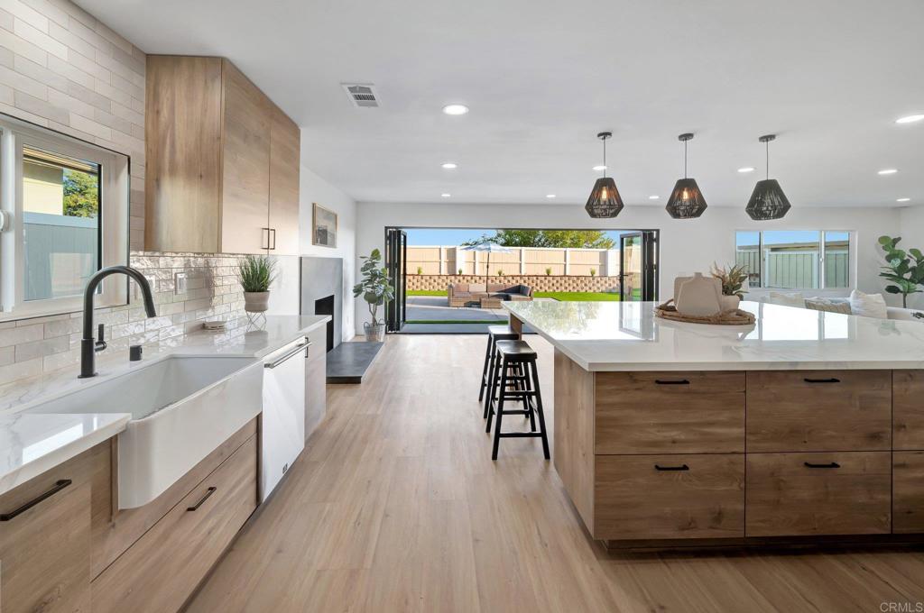 a kitchen with stainless steel appliances granite countertop a sink stove and wooden floor