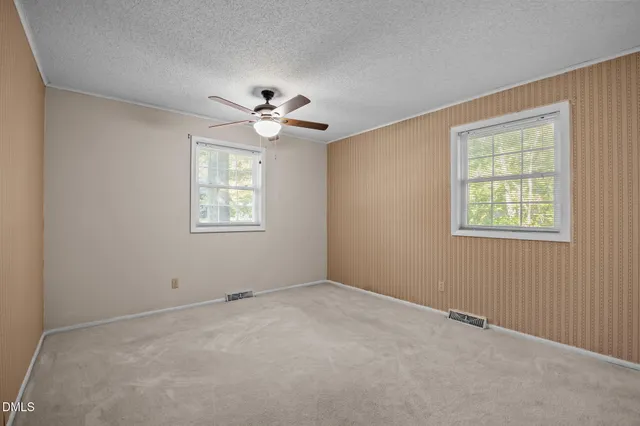 a view of an empty room with a ceiling fan