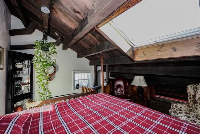 a bedroom with a bed and a lamp on dresser