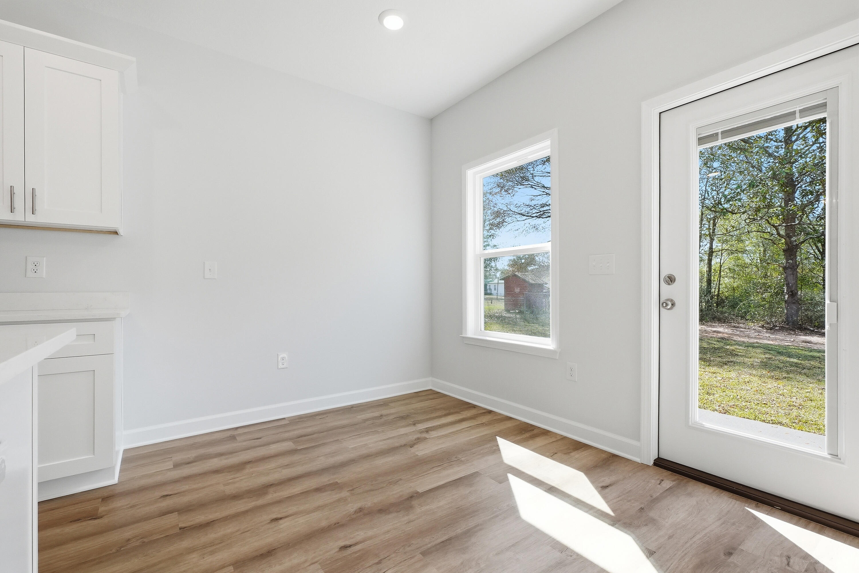 6138 Clover Street Crestview, FL 32539 - Photo 6 of 21 a view of an empty room with wooden floor and a window