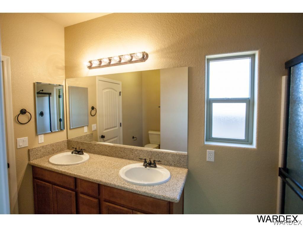4830 North Neal Ranch Road Kingman, AZ 86401 - Photo 10 of 13 a bathroom with a granite countertop sink and a mirror