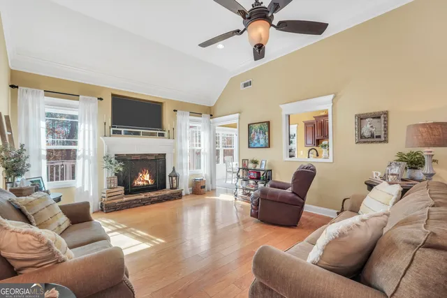 a living room with furniture a flat screen tv and a fireplace