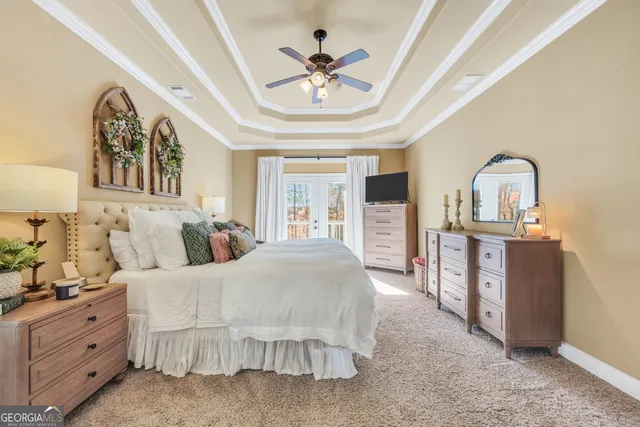 a spacious bedroom with a large bed and a chandelier