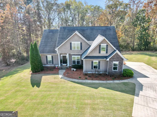 a view of house with outdoor space tub and trees in the background