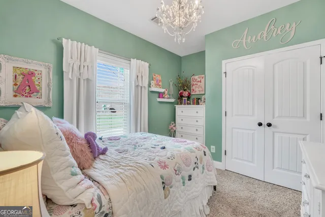 a bedroom with a bed and a chandelier