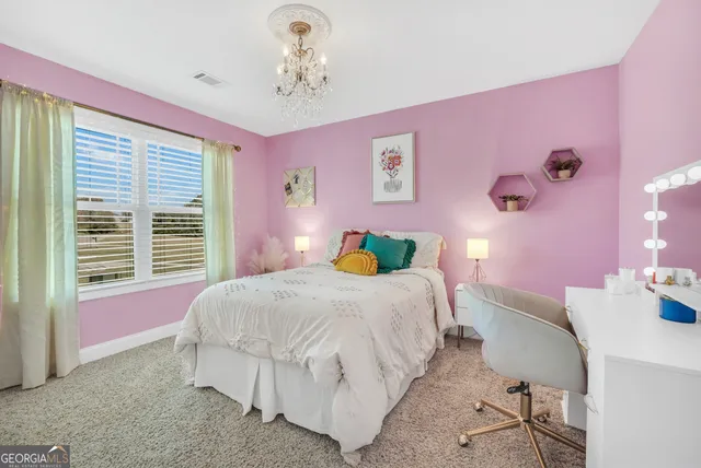 a bedroom with a bed chandelier and a window