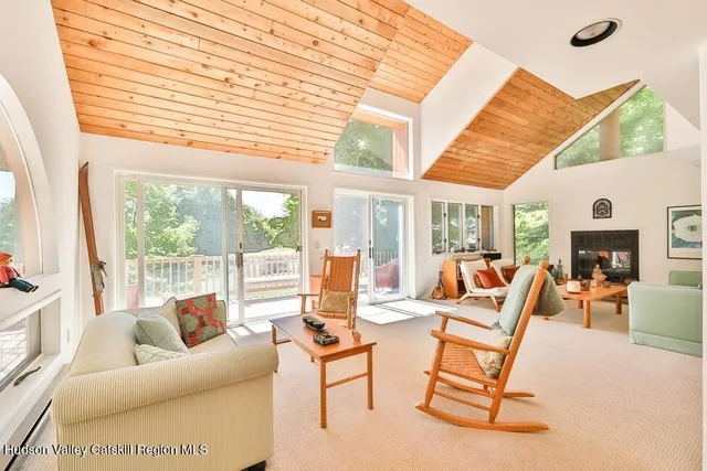 a living room with furniture a fireplace and a large window