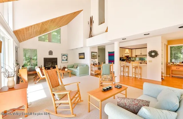 a living room with furniture kitchen view and a large window