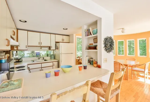 a dining room with furniture a large window and kitchen view