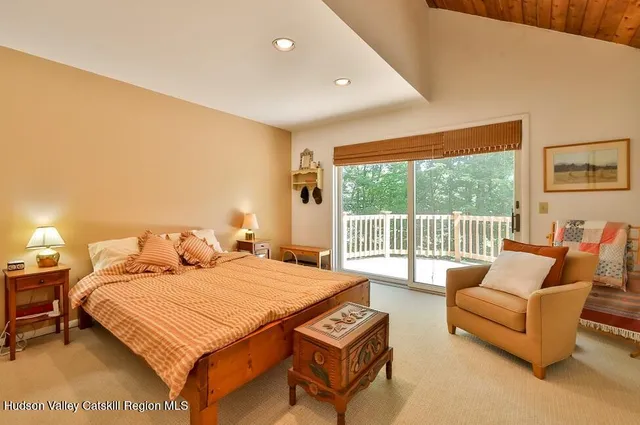 a bedroom with a bed a couch and a large window with outer view