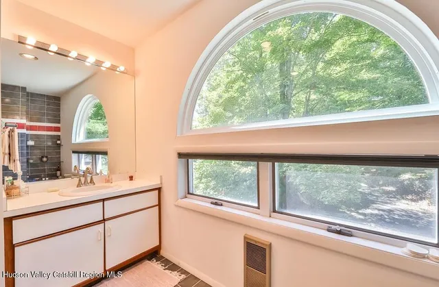 a bathroom with a sink window and mirror