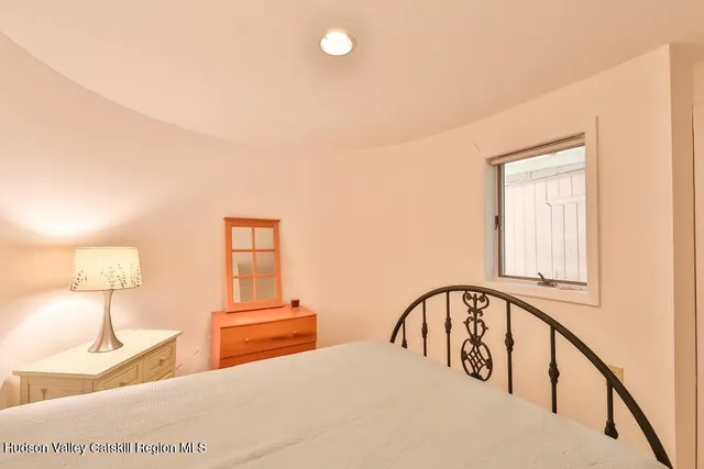 a bedroom with a bed a mirror and lamp