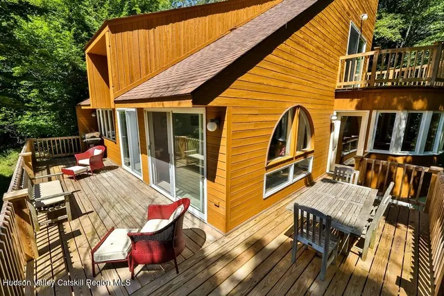 a view of a patio with table and chairs with wooden floor and fence