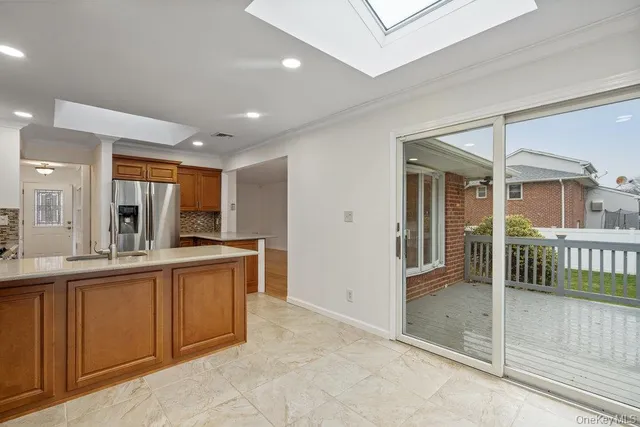 a large white kitchen with stainless steel appliances granite countertop a refrigerator and a sink