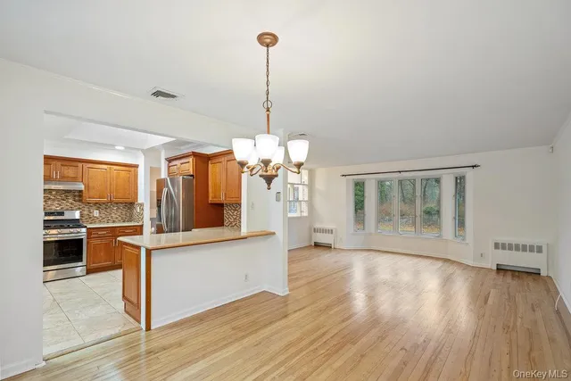 a view of a kitchen with wooden floor and a window