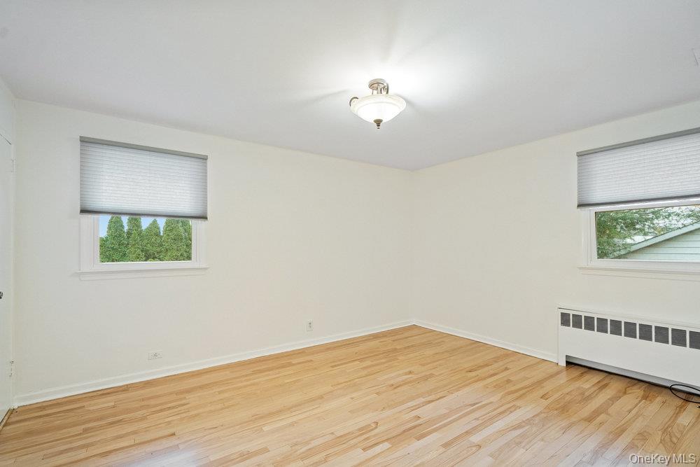 15 Morris Drive Syosset, NY 11791 - Photo 19 of 32 a view of an empty room with wooden floor and a window