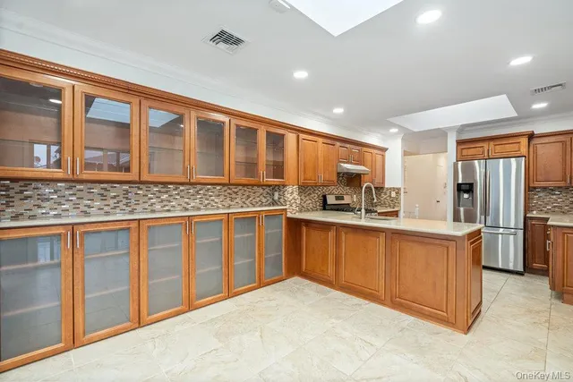 a kitchen with stainless steel appliances granite countertop a refrigerator and wooden cabinets