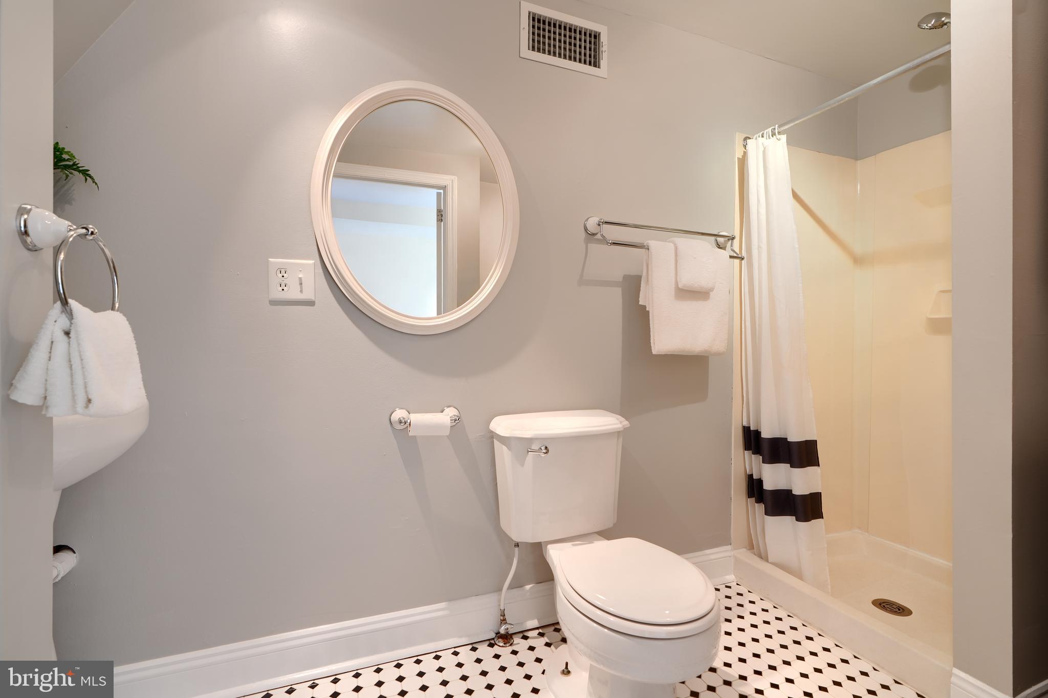1142 Riverside Avenue Baltimore, MD 21230 - Photo 22 of 41 a white toilet sitting next to a bathroom sink and a mirror