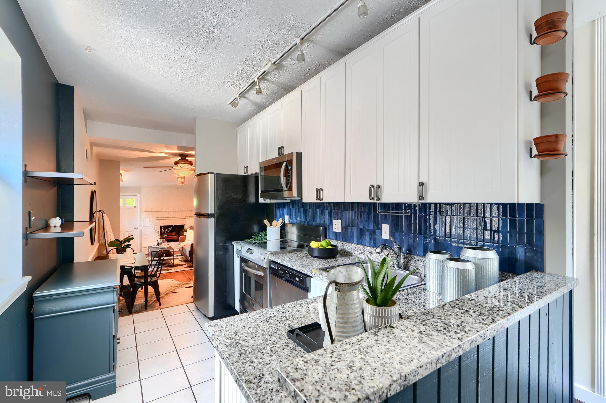 1142 Riverside Avenue Baltimore, MD 21230 - Photo 5 of 41 a kitchen with a table chairs and a refrigerator