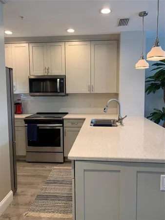 a kitchen with stainless steel appliances a stove a sink and a microwave