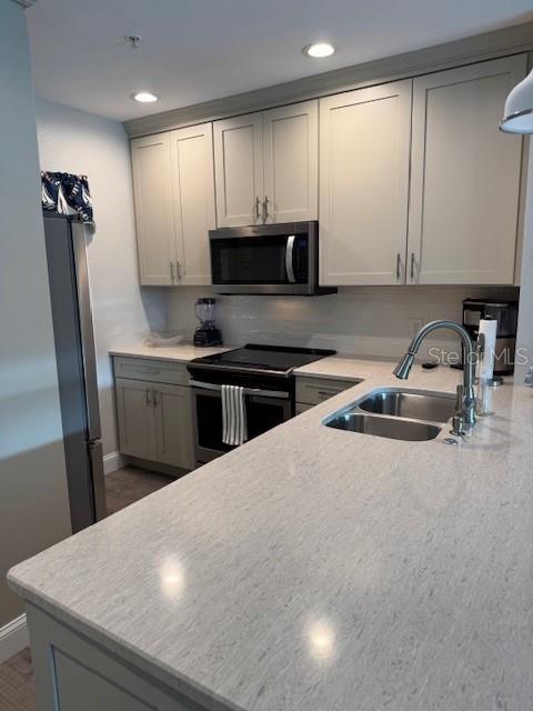 8411 Placida Road, Unit 205 Placida, FL 33946 - Photo 34 of 51 a kitchen with stainless steel appliances a sink a stove a microwave a refrigerator a counter top space and cabinets