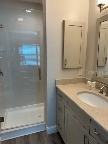 a bathroom with a granite countertop sink mirror and a bathtub